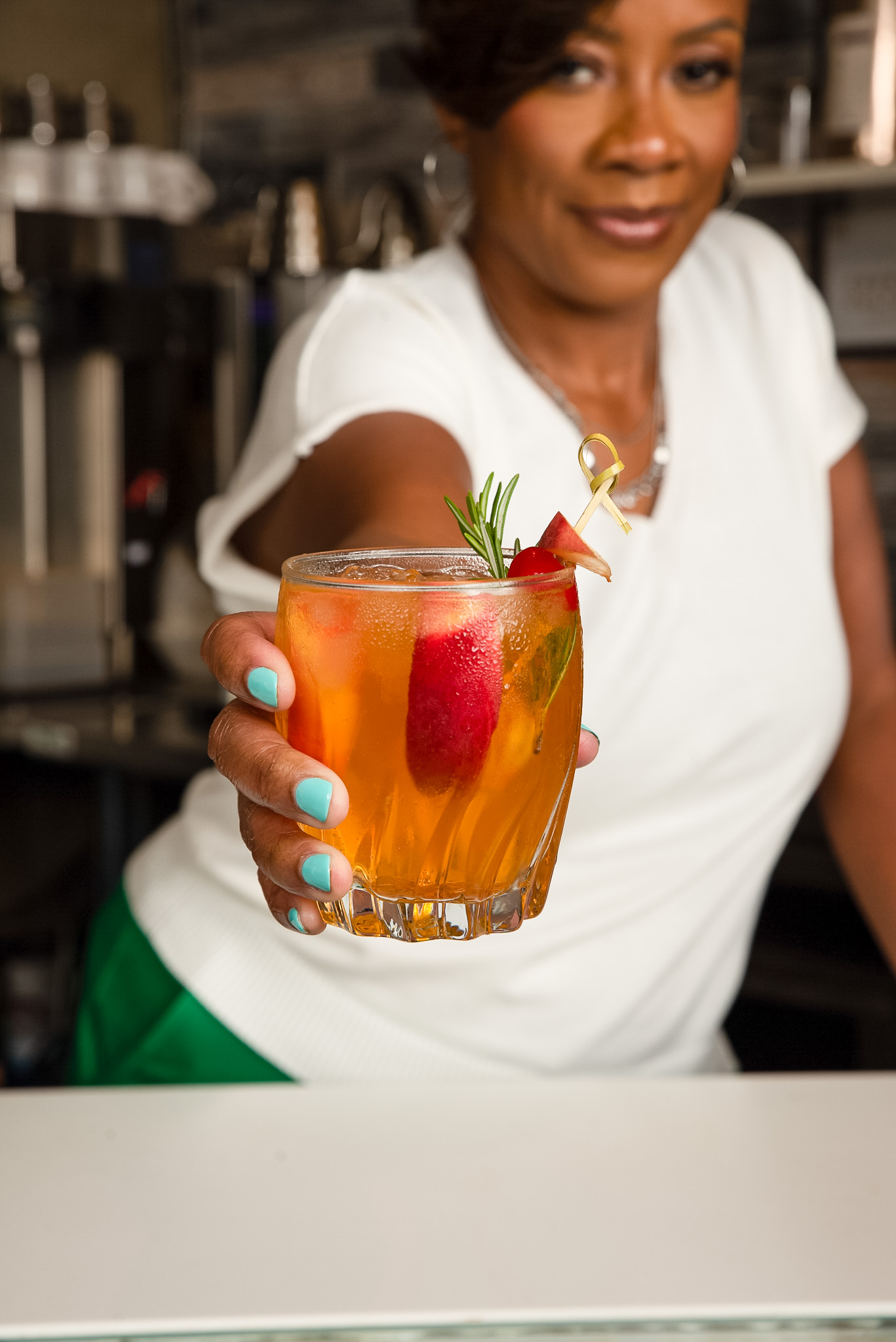 Handing a garnished signature cocktail to a guest